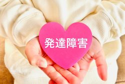発達障害と書かれたハート型のものを持つ手